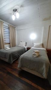 a bedroom with two beds and a window at Hostal Las Heras in Temuco