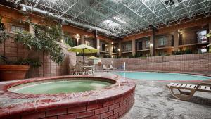 a swimming pool in a building with a brick wall at Best Western of Alexandria Inn & Suites & Conference Center in Alexandria