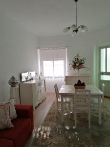 a living room with a table and a red couch at Alojamento Justo - vila de Montargil in Montargil +3 photos