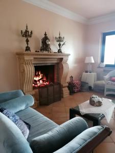 sala de estar con chimenea y sofá en La casa in campagna, en Aragona