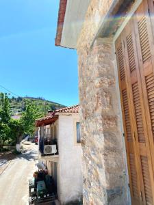 a house with a tractor parked next to a building at Traditional Stone House in Chandrinos in Khandrinós