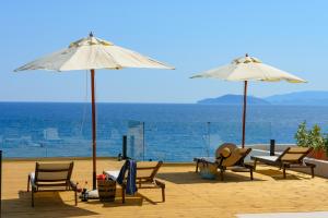 a group of chairs and umbrellas on a beach at Beachfront Villa Phi φ in Agios Nikolaos