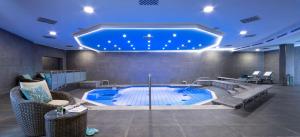 een groot zwembad met een blauw plafond bij Dorint Hotel Dresden in Dresden