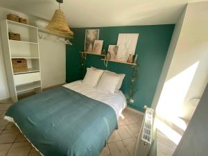 1 dormitorio con cama y pared verde en La Cascade verte /Appartement /jardin /parking en Braux