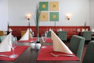 a table with red napkins and wine glasses on it at Livenwork Hotel & CoWorking GVZ Ingolstadt in Ingolstadt