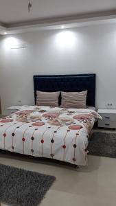a bedroom with a bed with a comforter on it at Ain Zaghouan en face de Tunisia Mall Lac 2 in Tunis