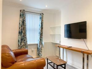 salon ze skórzanym fotelem i telewizorem z płaskim ekranem w obiekcie 147 knapp road house w Londynie