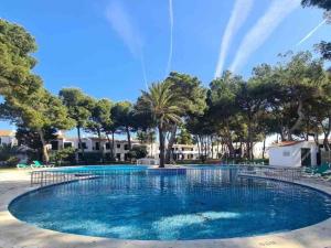 a large swimming pool with a rainbow in the background at Sa Mar in Cala'n Bosch