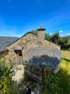 uma antiga casa de pedra com um telhado em Galicia Retreat em Santa Marta de Ortigueira