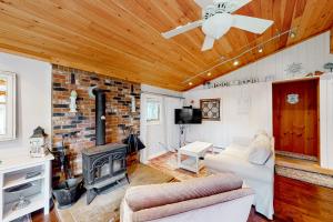 sala de estar con chimenea y ventilador de techo en 99 Fishing Access Road, en Ludlow