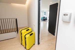 a yellow suitcase sitting in a room next to a door at Mont des Olives - Cap D'ail- app4 in Saint-Antoine