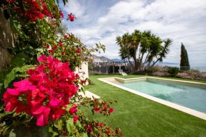 a garden with a swimming pool and red flowers at Mont des Olives - Cap D'ail- app4 in Saint-Antoine
