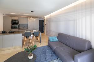 a living room with a couch and a kitchen at Mont des Olives - Cap D'ail- app4 in Saint-Antoine