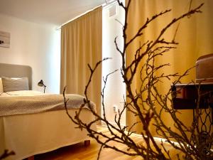 a bedroom with a bed and a plant in the foreground at Trelleborg Central Vila in Trelleborg