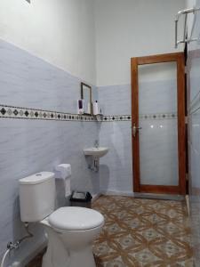 a bathroom with a toilet and a sink at Santhi Guna Bungalow in Nusa Penida
