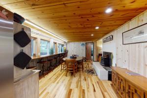 a kitchen and living room with a wooden ceiling at Ice Creek Hollow Wood Den at Wallowa Lake in Joseph