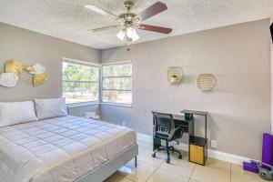 Un dormitorio con una cama, un escritorio y un ventilador de techo. en Deerfield Delight, en Deerfield Beach