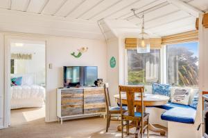 a room with a table and a tv and a bed at Seaside Cottage in Bodega Bay
