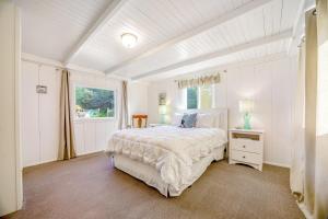 a white bedroom with a bed and a window at Seaside Cottage in Bodega Bay