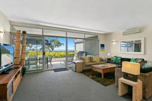 a living room with a couch and a tv at Apartment 20 Kalimna in Lorne