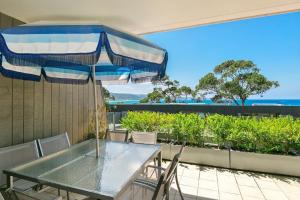 a table with chairs and an umbrella on a balcony at Apartment 20 Kalimna in Lorne