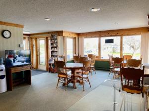 雅茅斯的住宿－New Age Inn - Voyageur，一间带桌椅和电视的用餐室