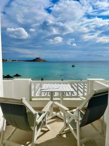 a white chair sitting on top of a beach at Acrogiali Beach Hotel Mykonos in Platis Gialos