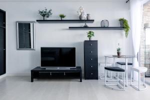 a living room with a television and a table and chairs at Blue Dream: Panoramic view on heights over the sea in La Matanza de Acentejo