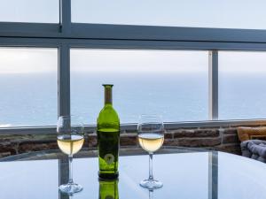 a bottle of white wine and two glasses on a table at Blue Dream: Panoramic view on heights over the sea in La Matanza de Acentejo