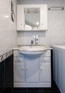 a bathroom with a white sink and a mirror at Blue Dream: Panoramic view on heights over the sea in La Matanza de Acentejo