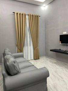 a living room with a couch and a television at afza Homestay Paka B in Paka