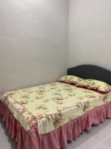 Una cama con una manta encima. en afza Homestay Paka B en Paka