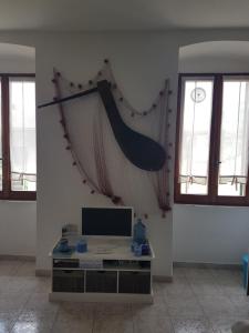 a living room with a tv and a net on the wall at Casa Mafalda in Corniglia