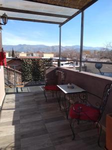 a patio with a table and chairs on a balcony at OLASCOAGA DOS monoambiente in Mendoza
