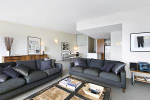 a living room with two couches and a kitchen at Apartment 25 Kalimna in Lorne