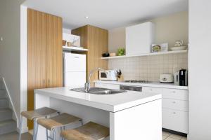 a white kitchen with a sink and a counter at Apartment 25 Kalimna in Lorne