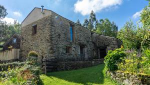 an old stone house with a garden in front of it at Galicia Retreat in Santa Marta de Ortigueira