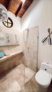 a bathroom with a toilet and a glass shower at Alquiler casa en la playa, Tolu in Tolú