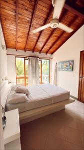 1 dormitorio con 1 cama grande y techo de madera en Alquiler casa en la playa, Tolu en Tolú