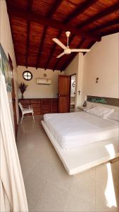 a bedroom with a large bed with a ceiling fan at Alquiler casa en la playa, Tolu in Tolú