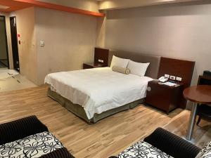ein Schlafzimmer mit einem großen Bett und einem Tisch in der Unterkunft Chia Shih Pao Hotel in Taibao