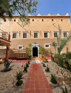 un gran edificio con un camino de ladrillo delante de él en Kasbah ben Ali, en Kalaat MGouna