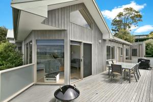 a patio with a table and chairs on a deck at Lorne Central in Lorne