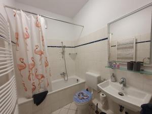 a bathroom with a toilet and a shower curtain with flamingos on it at Am Pontepark in Görlitz +14 photos