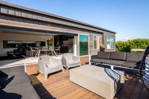 a patio with a couch and chairs on a deck at Pinot Paradise in Martinborough