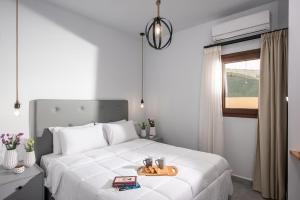 Un dormitorio con una cama blanca y una bandeja. en Iris Villa 2 - Archanes Crete, en Káto Arkhánai