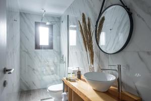 baño con lavabo y espejo en la pared en Iris Villa 2 - Archanes Crete, en Káto Arkhánai