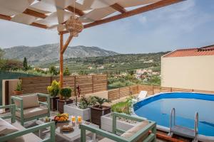 un patio con piscina, mesa y sillas en Iris Villa 1 - Archanes Crete en Káto Arkhánes