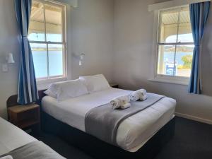 a bedroom with a large bed with towels on it at Mangonui Hotel in Mangonui