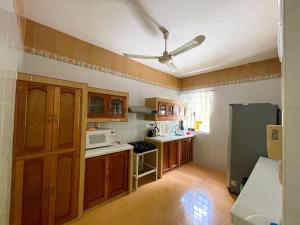 a kitchen with wooden cabinets and a ceiling fan at BELLAVISTA HOUSE /Increíble sala in Campeche